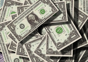 Stack of one dollar bills representing financial investment and savings for homeownership.