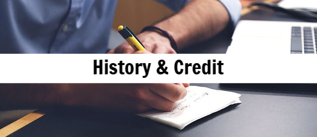 Person writing notes with a pen on a notepad, symbolizing the importance of payment history and credit for cash-out refinancing on a land contract.